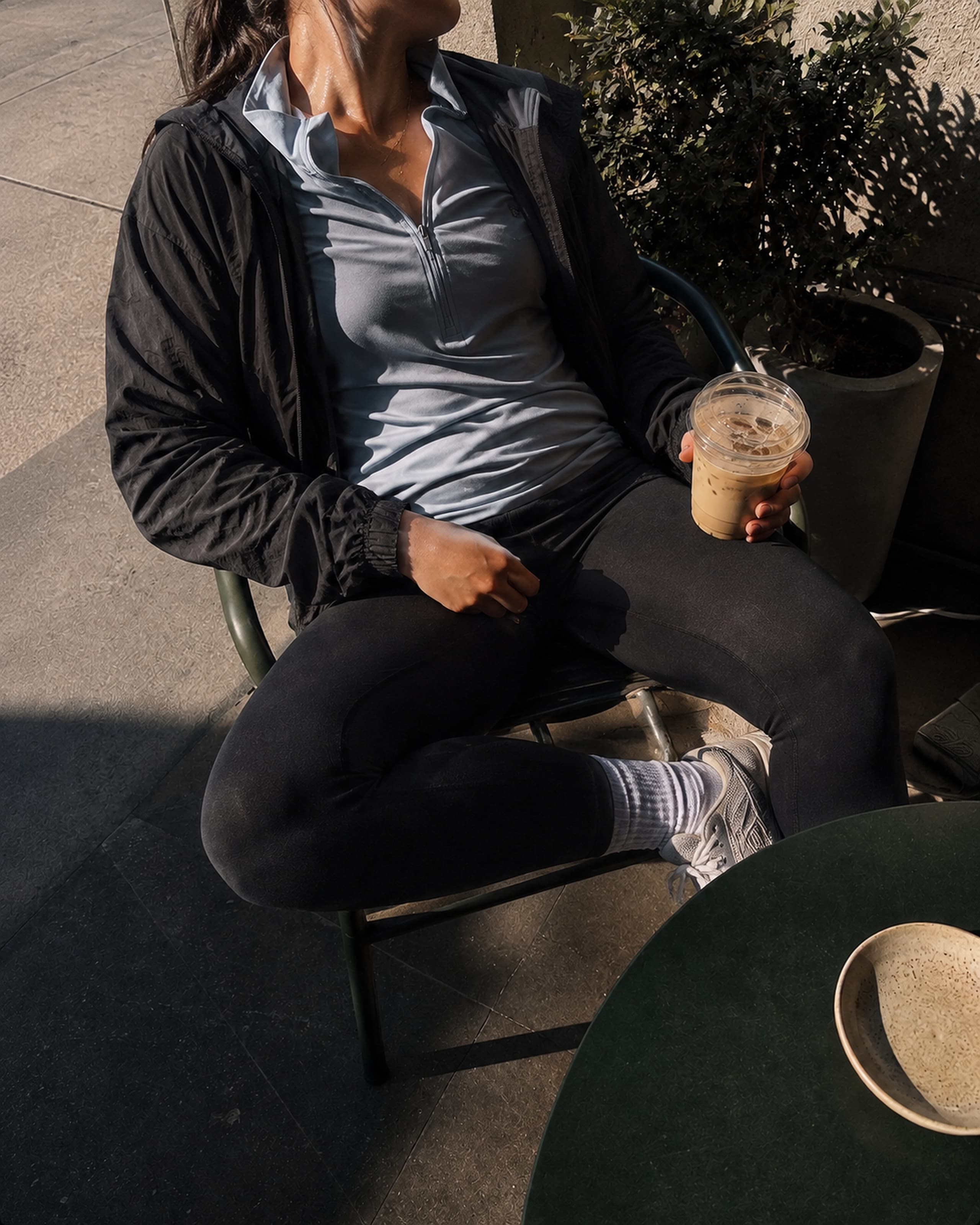 A moment of stillness after a run — sitting in the sun with an iced coffee.
