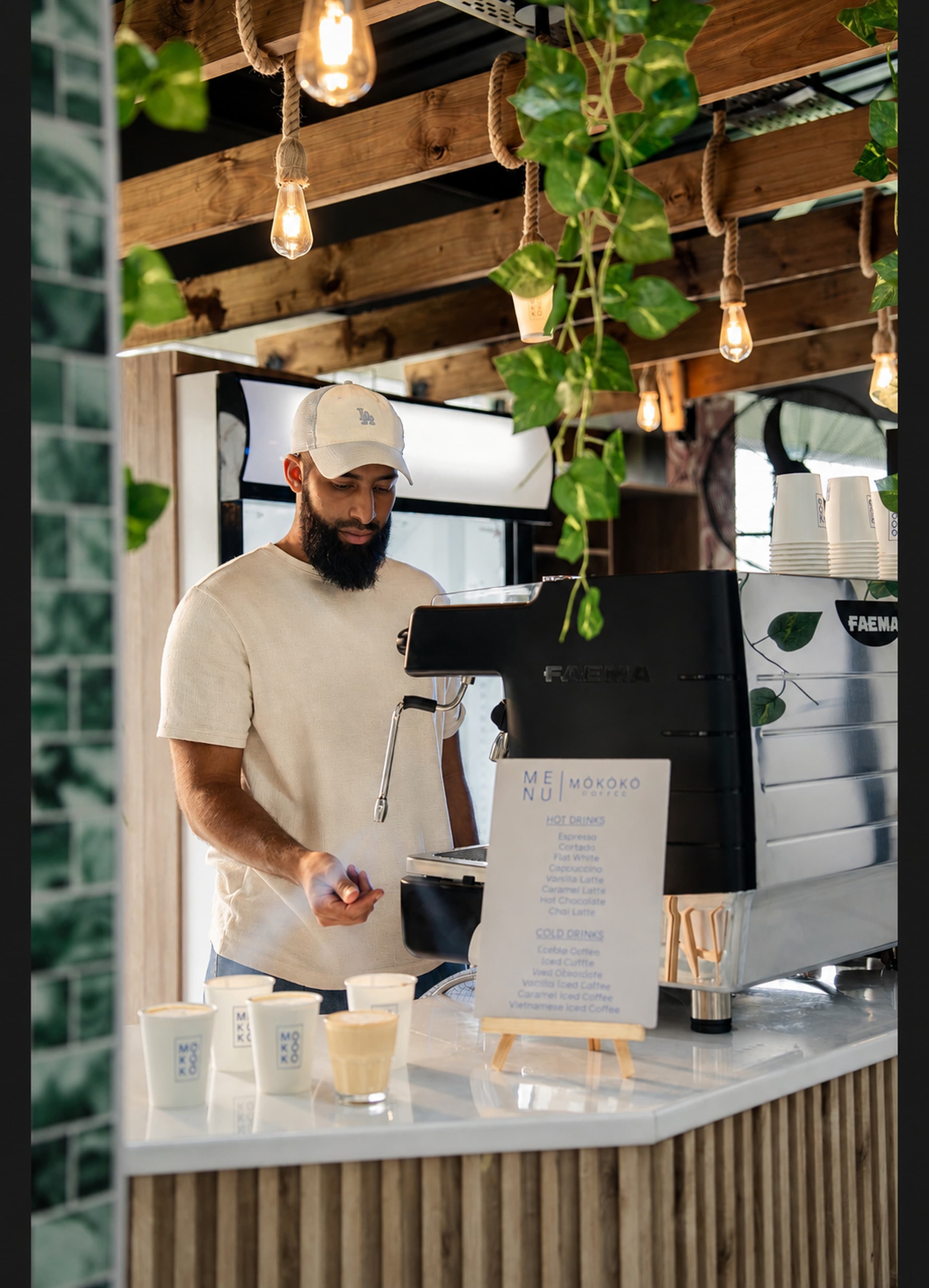 A barista preparing coffee at a bright MOKOKO setup — craft and service.
